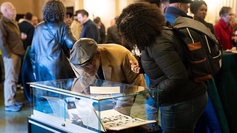 People look at items in a display case in the Bridges Auditorium lobby.